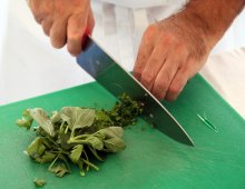 un uomo intento nell'affettare le verdure