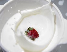 Una fragola sprofonda in una tazza di latte