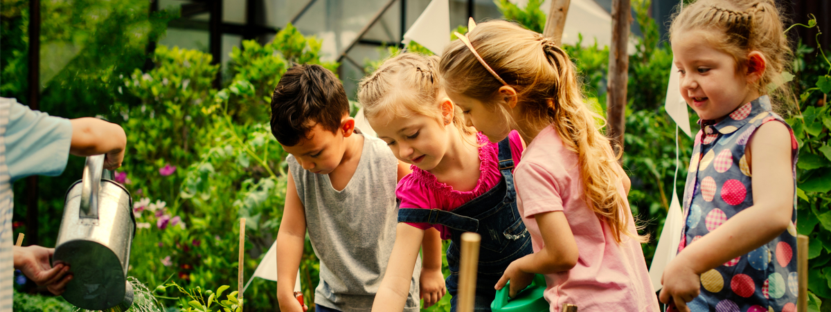 bambini che innaffiano il giardino