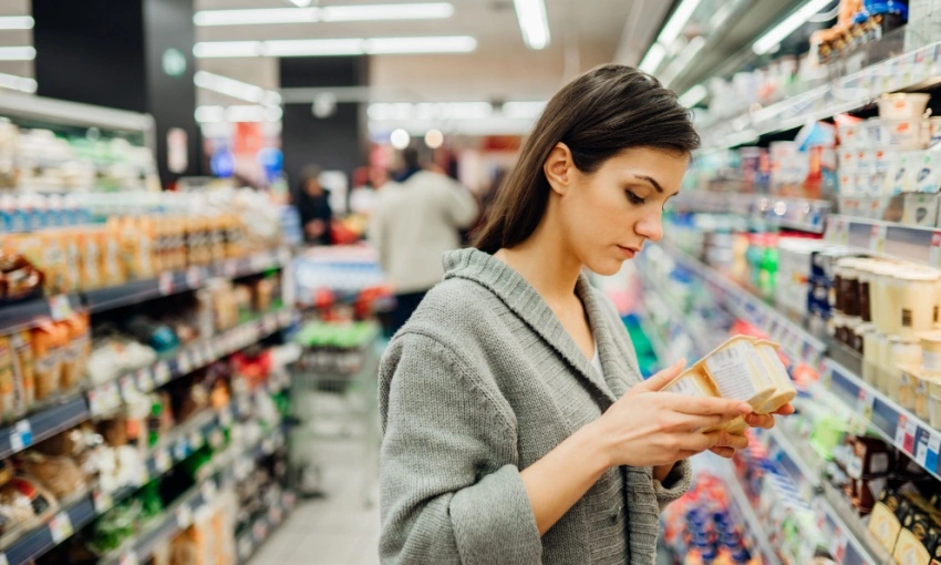 Donna che legge l'etichetta di un alimento al supermercato