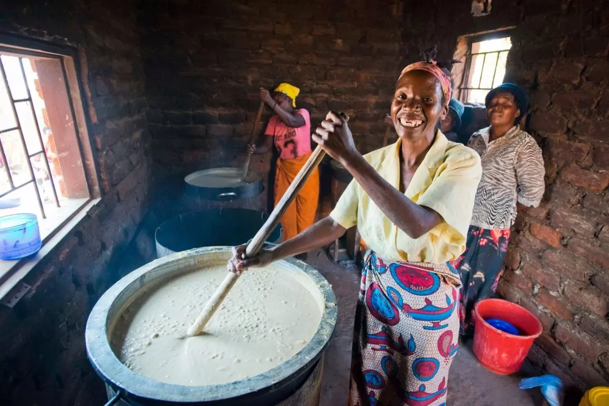 Donne che cucinano un pentolone pieno di porridge