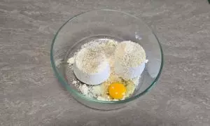 Ricotta, uovo e formaggio grattugiato in una ciotola