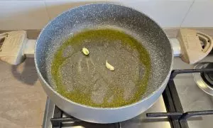 Spicchi d'aglio in pentola con giro d'olio