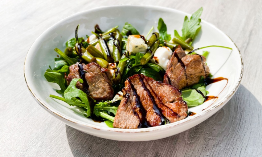 Piatto di carne e insalata condito con aceto balsamico