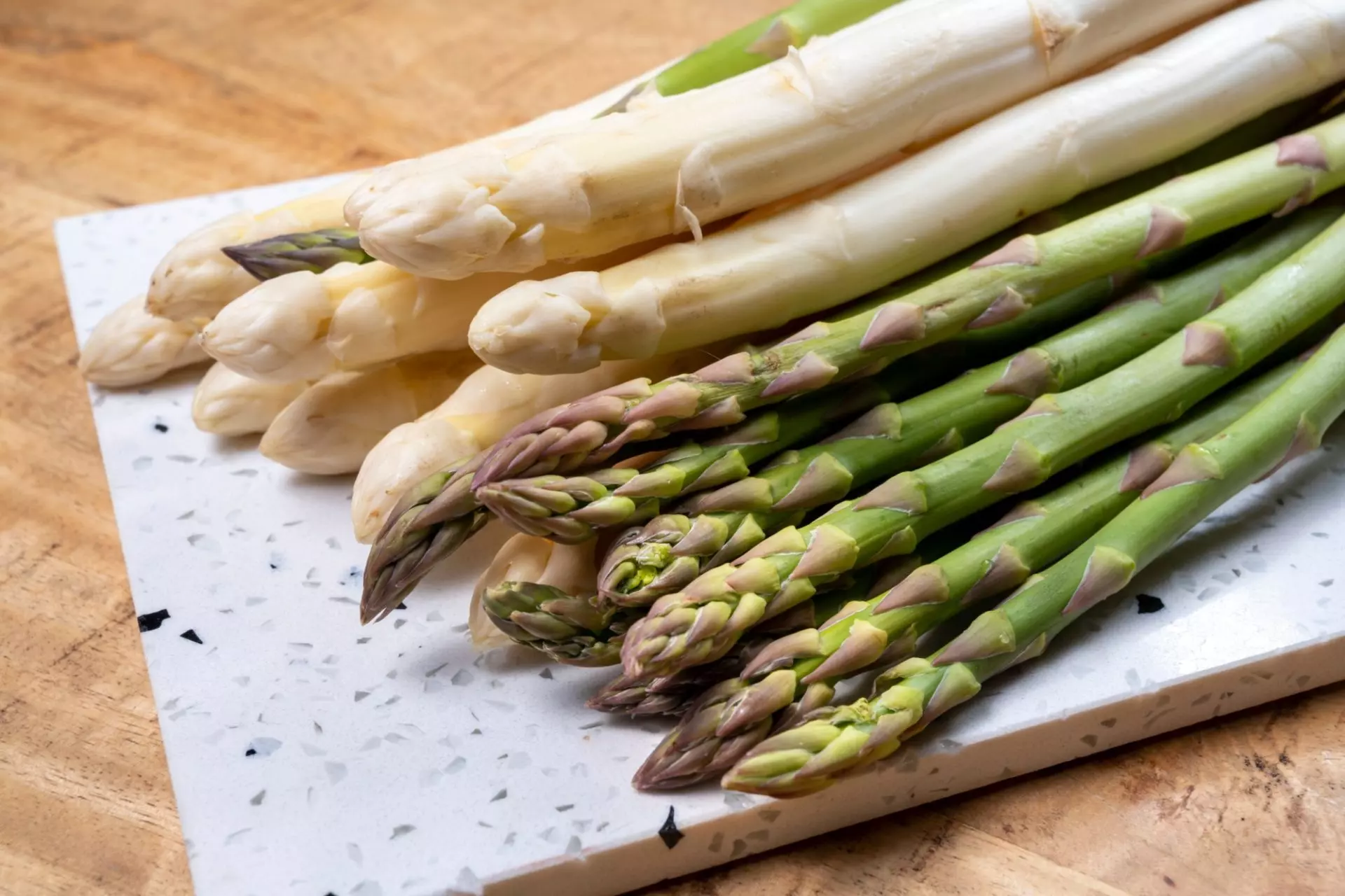 asparagi bianchi e verdi su tagliere di legno