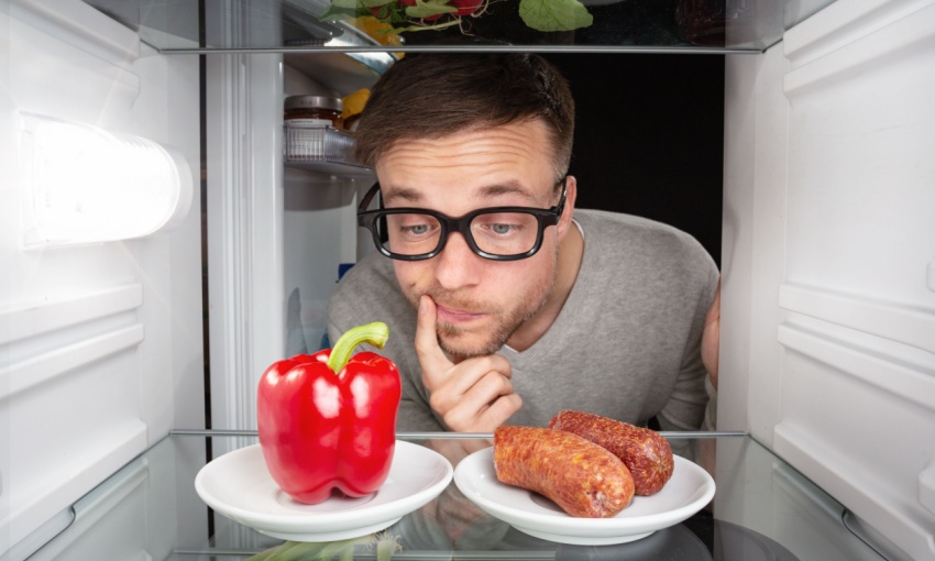 un uomo indeciso se scegliere carne o verdura