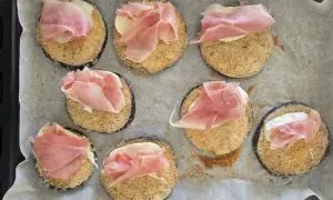 fettina di prosciutto cotto aggiunta alla melanzana panata e alla mozzarella