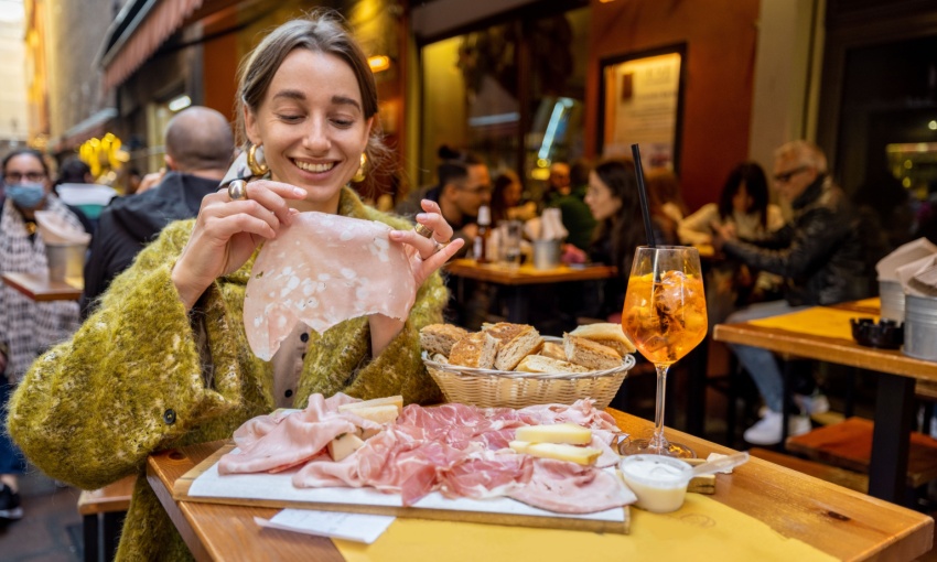 donna che mangia un tagliere di salumi