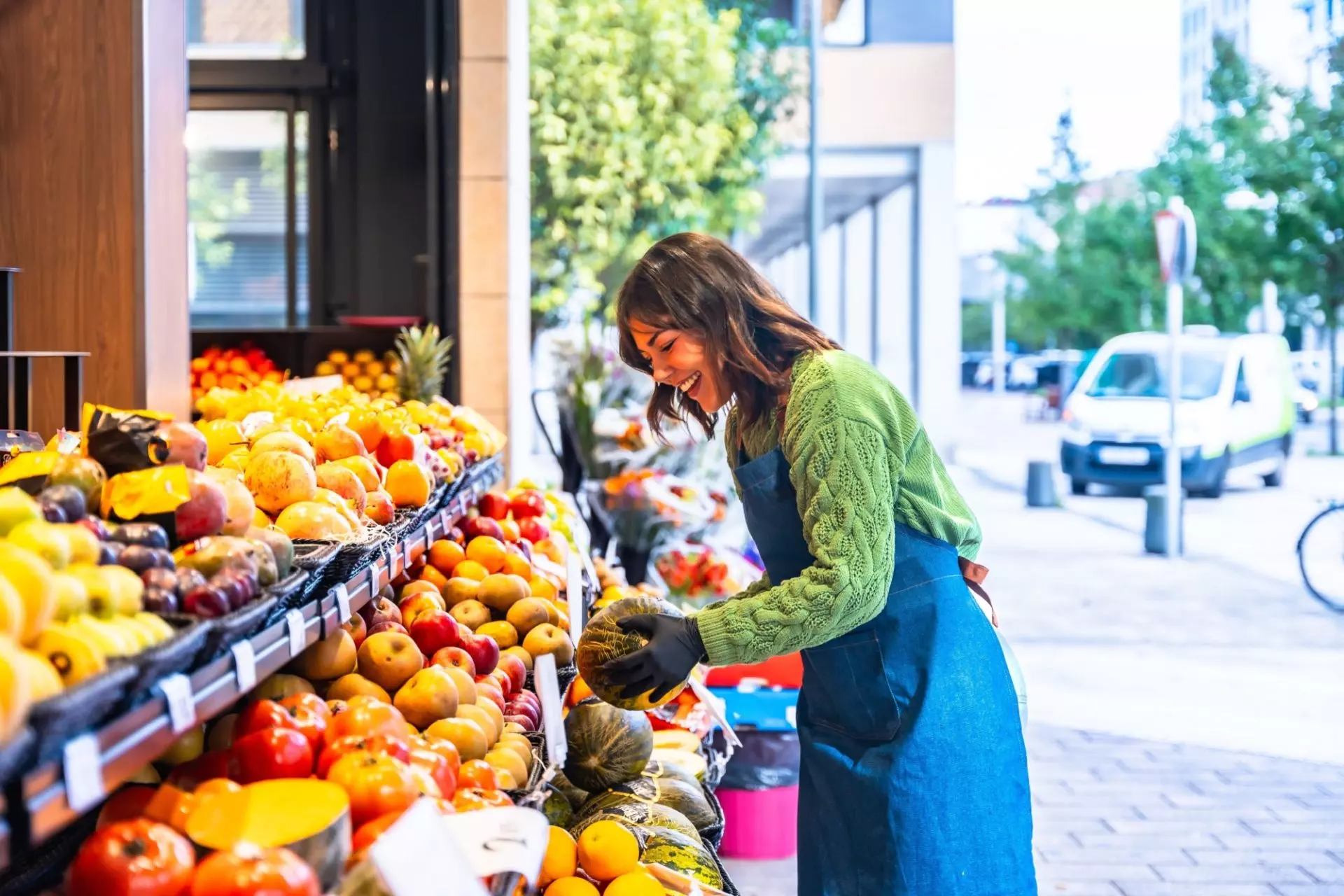 donna che sistema il banco della frutta e verdura