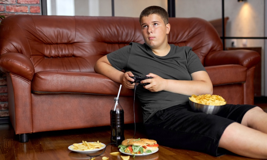 ragazzo che mangia cibo spazzatura