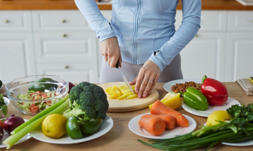 donna che taglia e cucina verdure