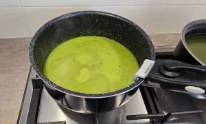 brodo aggiunto al riso e alla crema di asparagi