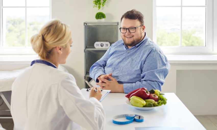 uomo obeso che parla con una nutrizionista/medico