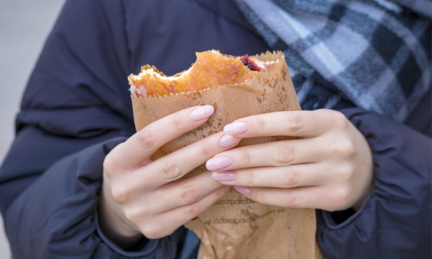 donna con panino con carta intorno