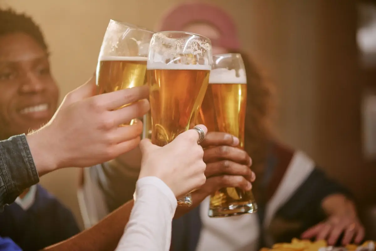 ragazzi che brindano con una birra