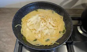 spaghetti in padella con tutti gli ingredienti, pronti da amalgamare