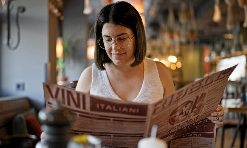 donna che legge menù al ristorante